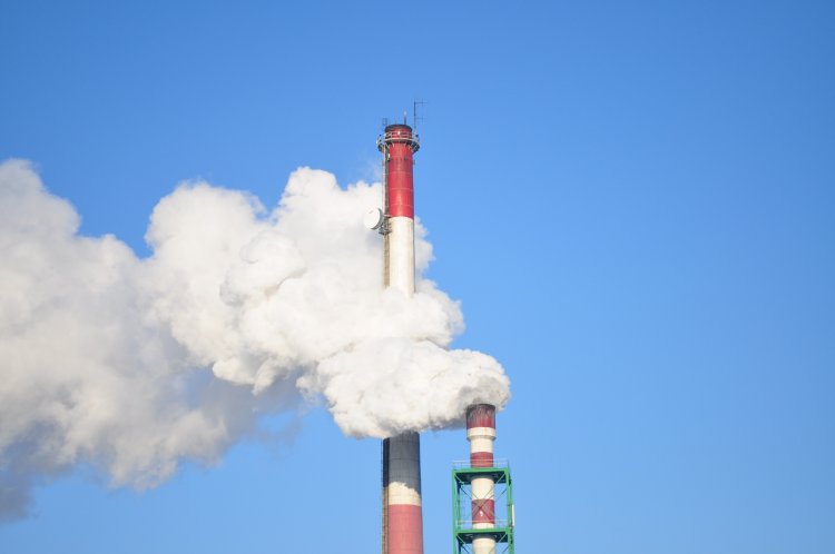 Smoke stacks billowing white fumes.