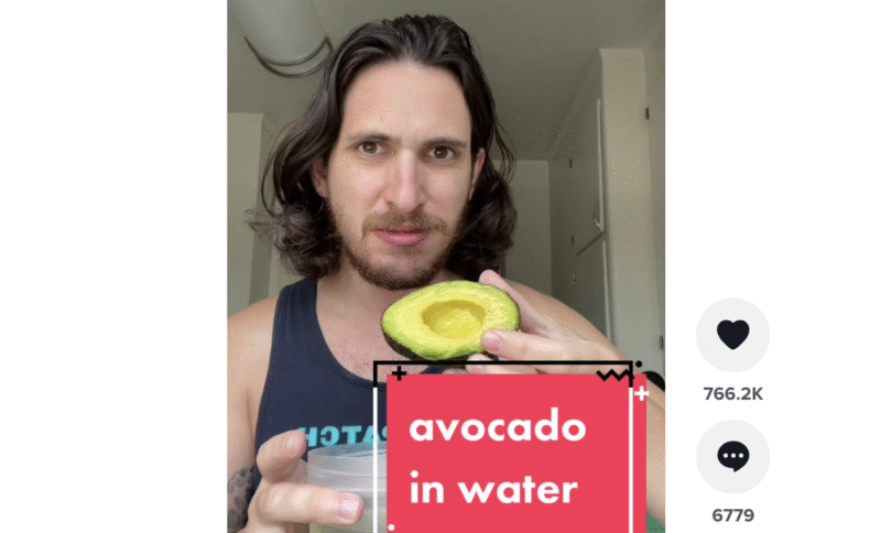 Screenshot of TikTok with a man holding a avocado with text reading "avocado in water."